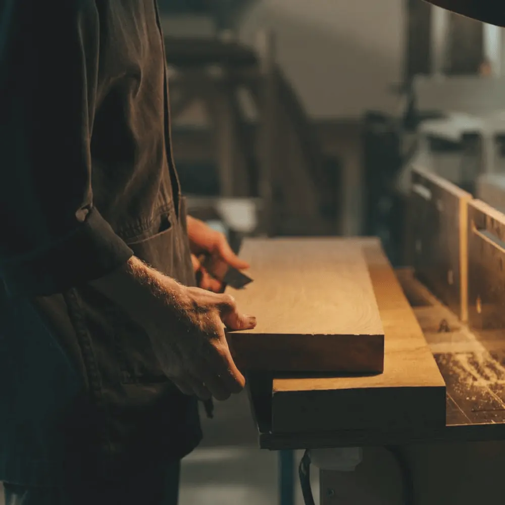 Artisan travaillant sur une pièce de bois dans un atelier