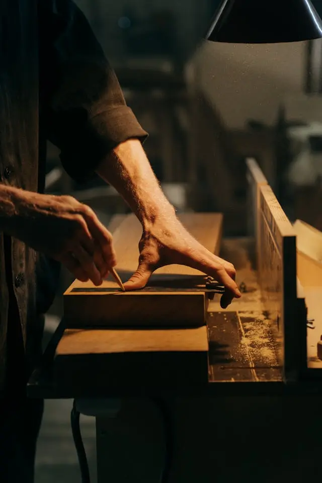 Menuisier prenant une mesure d'une pièce en bois